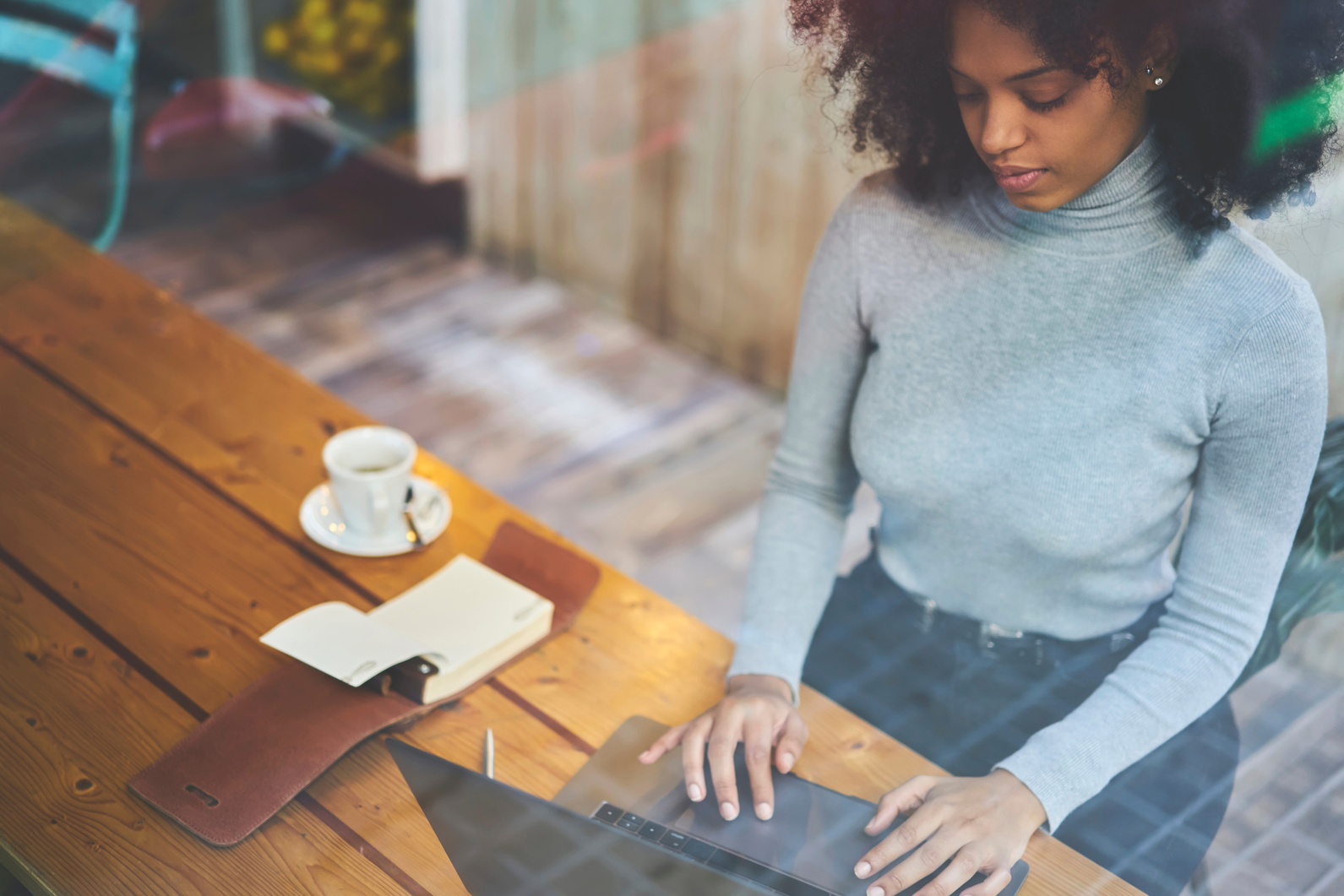 Focused black woman browsing laptop